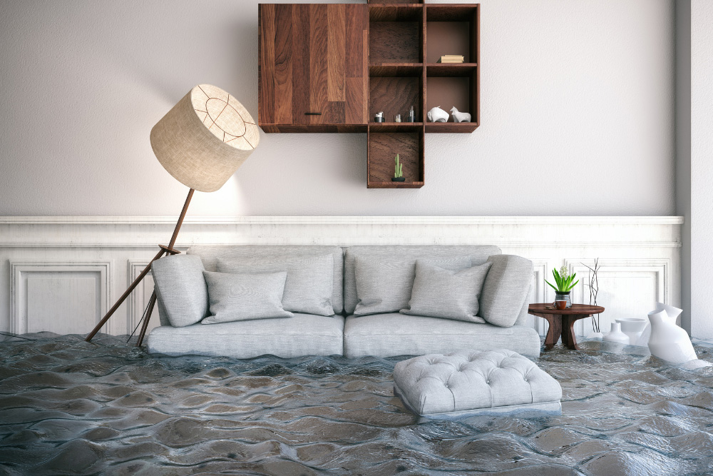 A flooded living room with a sofa floating in need of emergency flood cleanup near Redlands CA.
